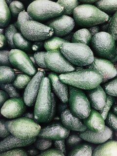 a pile of dark green avocados.