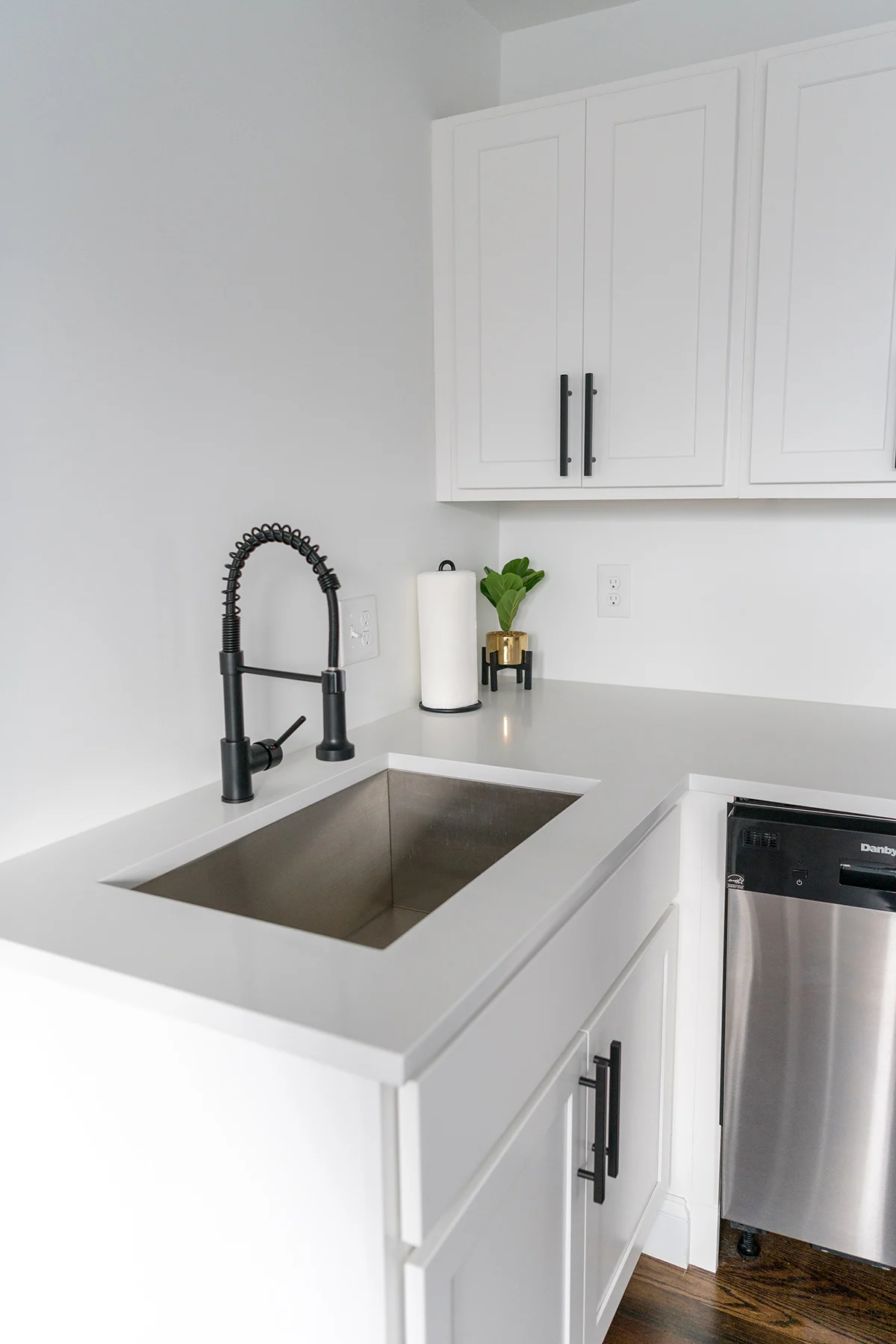 a fancy black faucet in a modern white kitchen.