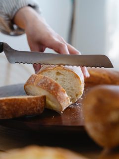 cutting a loaf of bread with a serrated knife.