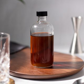 an apothecary bottle filled with dark brown simple syrup.