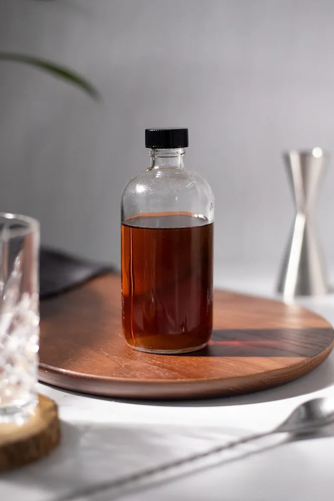 an apothecary bottle filled with dark brown simple syrup.