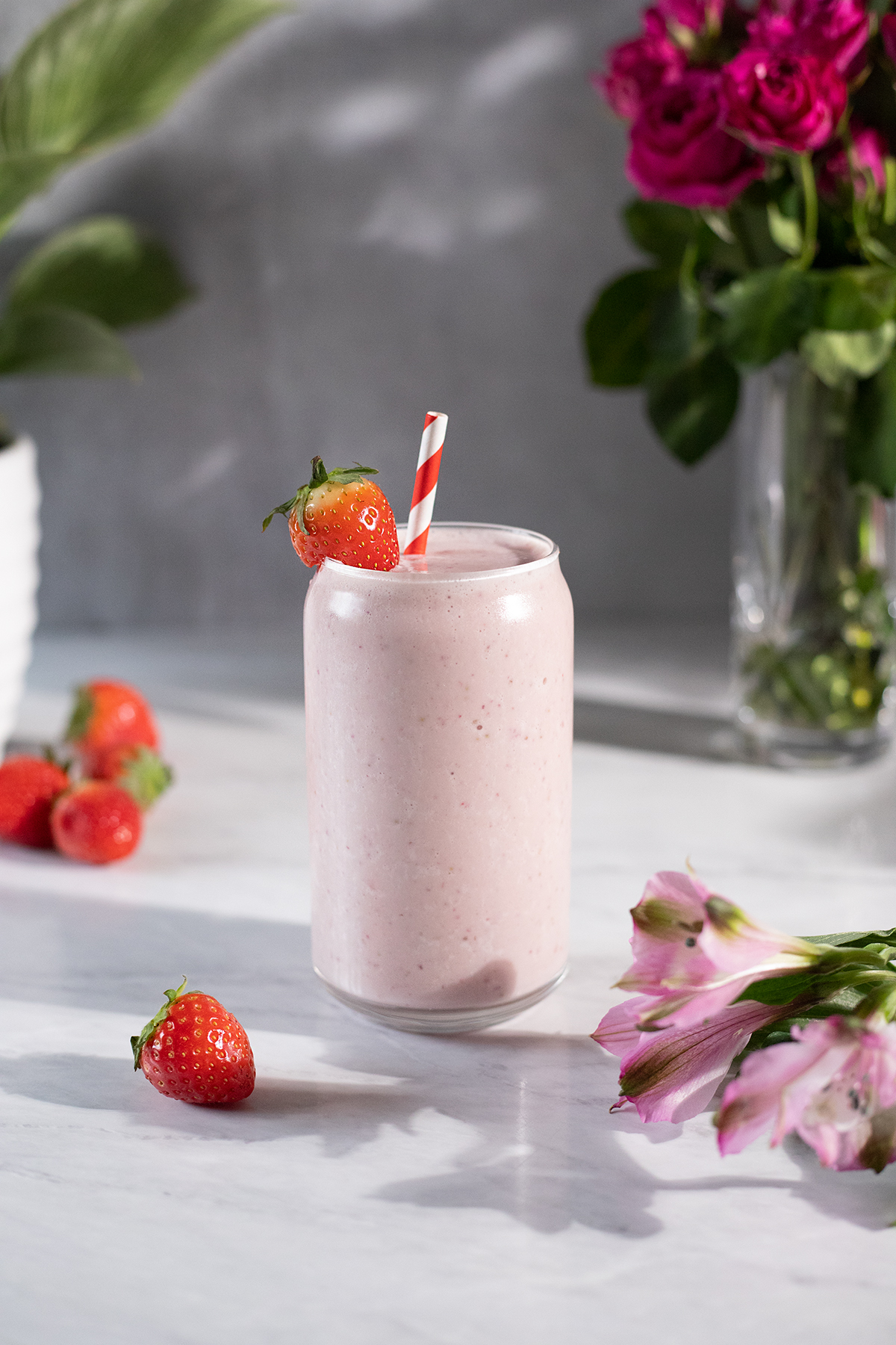 a creamy pale pink smoothie in a can-shaped glass.